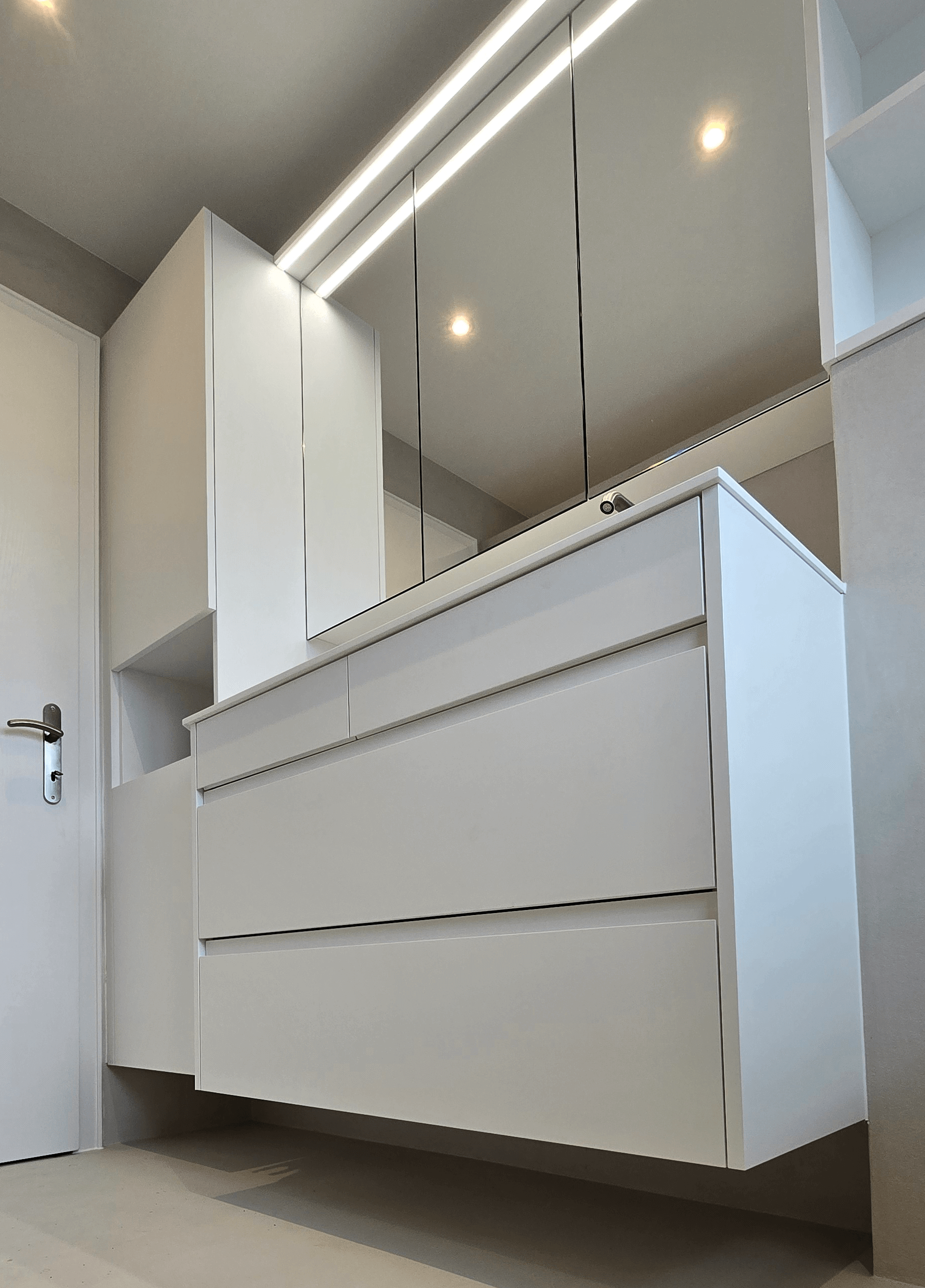 Badezimmer-Moebel in weiss matt, grifflos, weisse Kompaktplatte als Arbeitsplatte