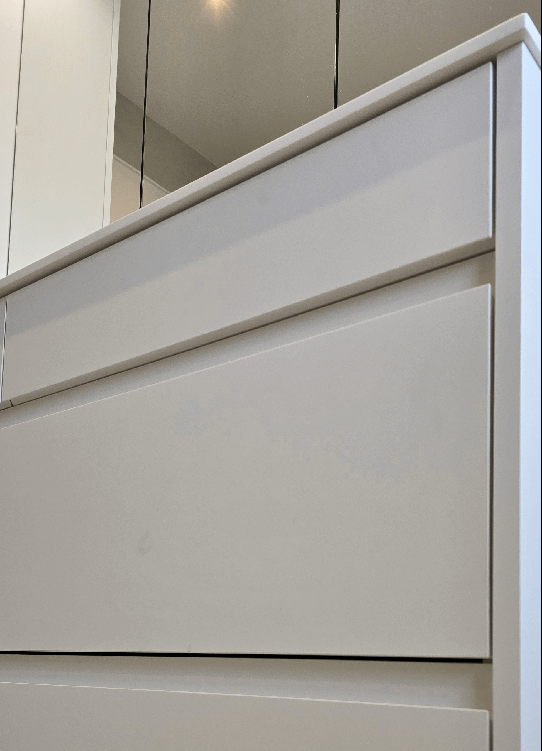 Badezimmer-Moebel in weiss matt, grifflos, weisse Kompaktplatte als Arbeitsplatte