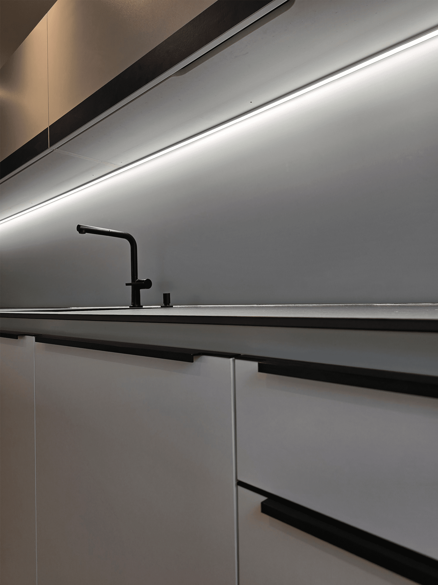 Renovierte Kueche mit Glasrueckwand, neuem Waschbecken und neuer Armatur.